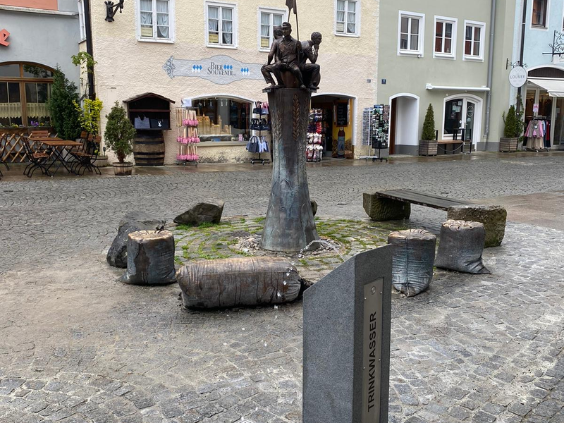 Trinkbrunnen am Schrannenplatz. Im Hintergrund sind Häuser zu sehen.